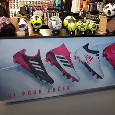 Bannière imprimée de chaussures de football rose et noir en vitrine de boutique