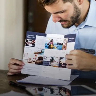 Homme consultant une brochure publicitaire imprimée