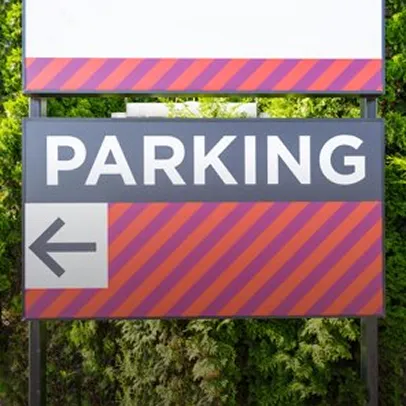 Panneau de parking directionnel avec flèche, fond orange et violet